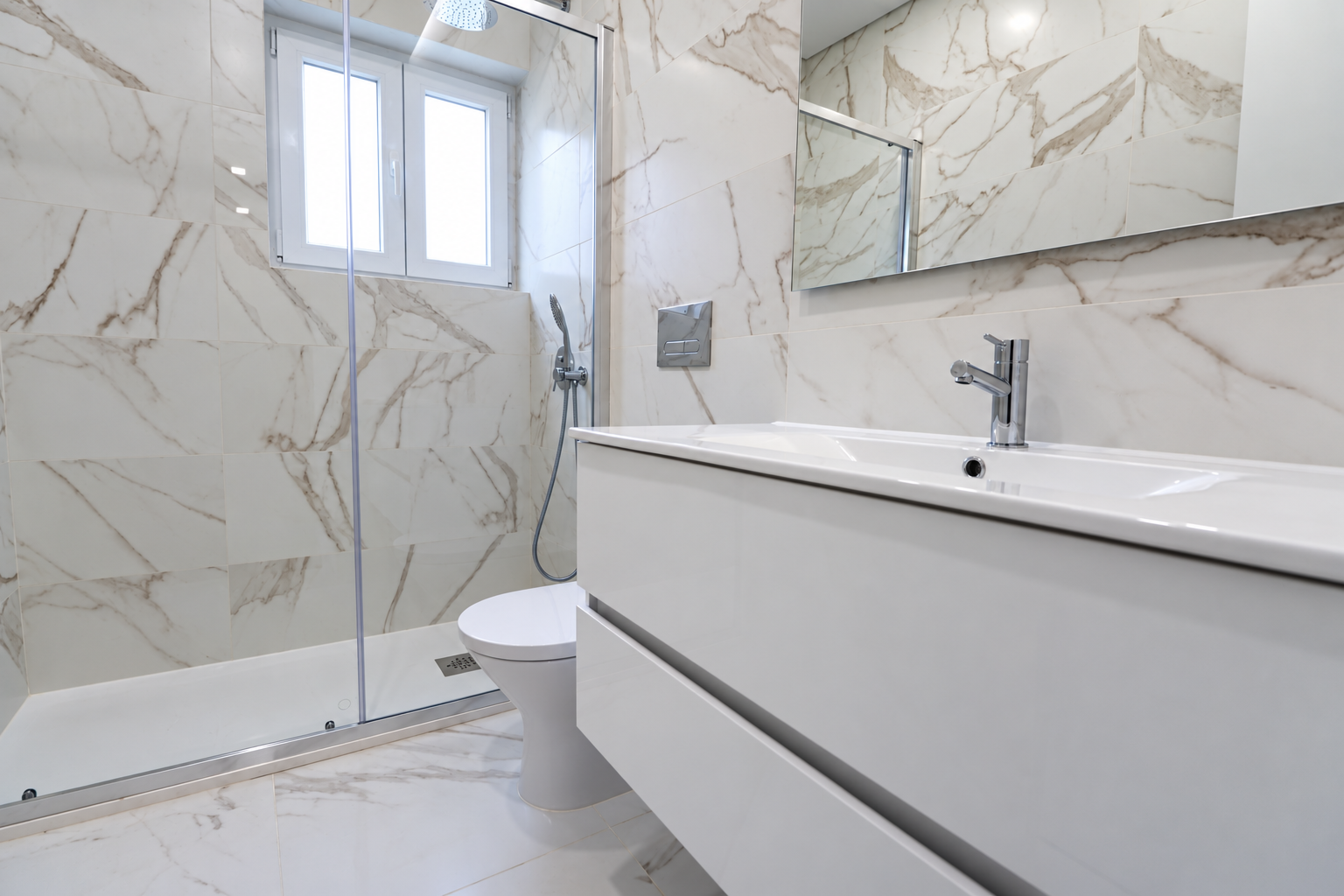 Bathroom with a glass-enclosed shower beside the window, a toilet and a washbasin on a white wall-hung vanity.
