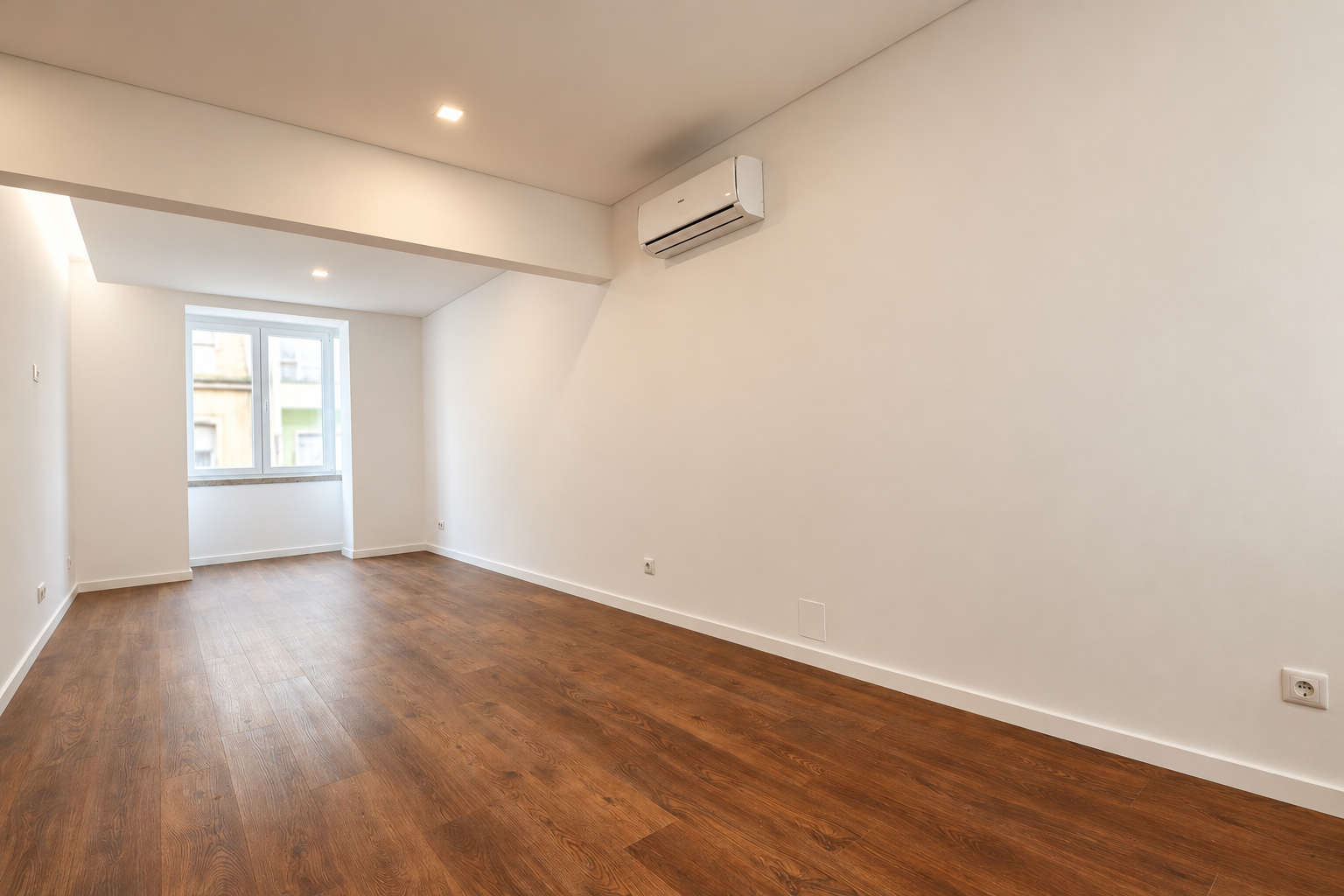 Living room with a window at the far end, wood-effect flooring and an air-conditioning unit on the right-hand wall.