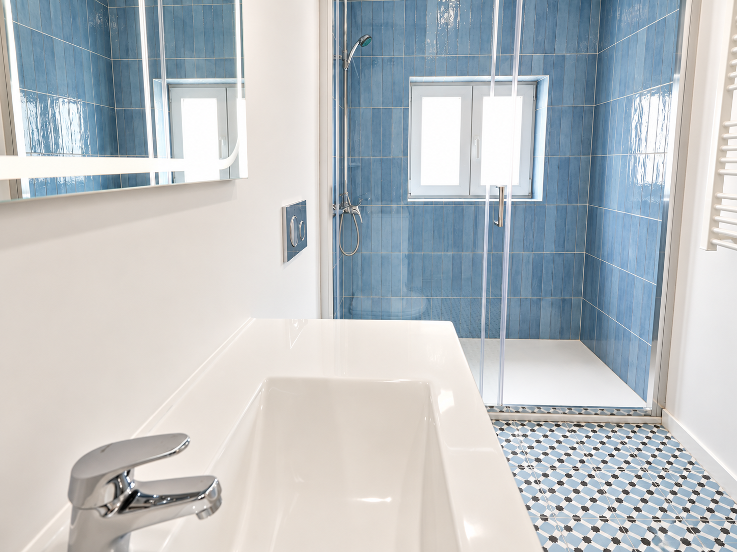 Bathroom with a white washbasin and blue tiles in Queijas