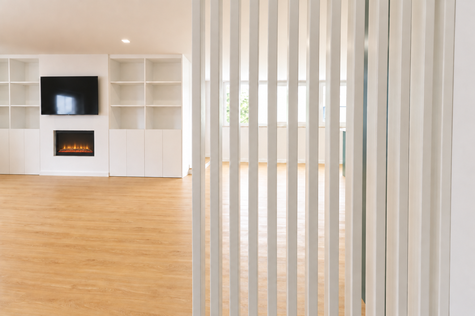 Living room with a fireplace and white slatted partition in Queijas