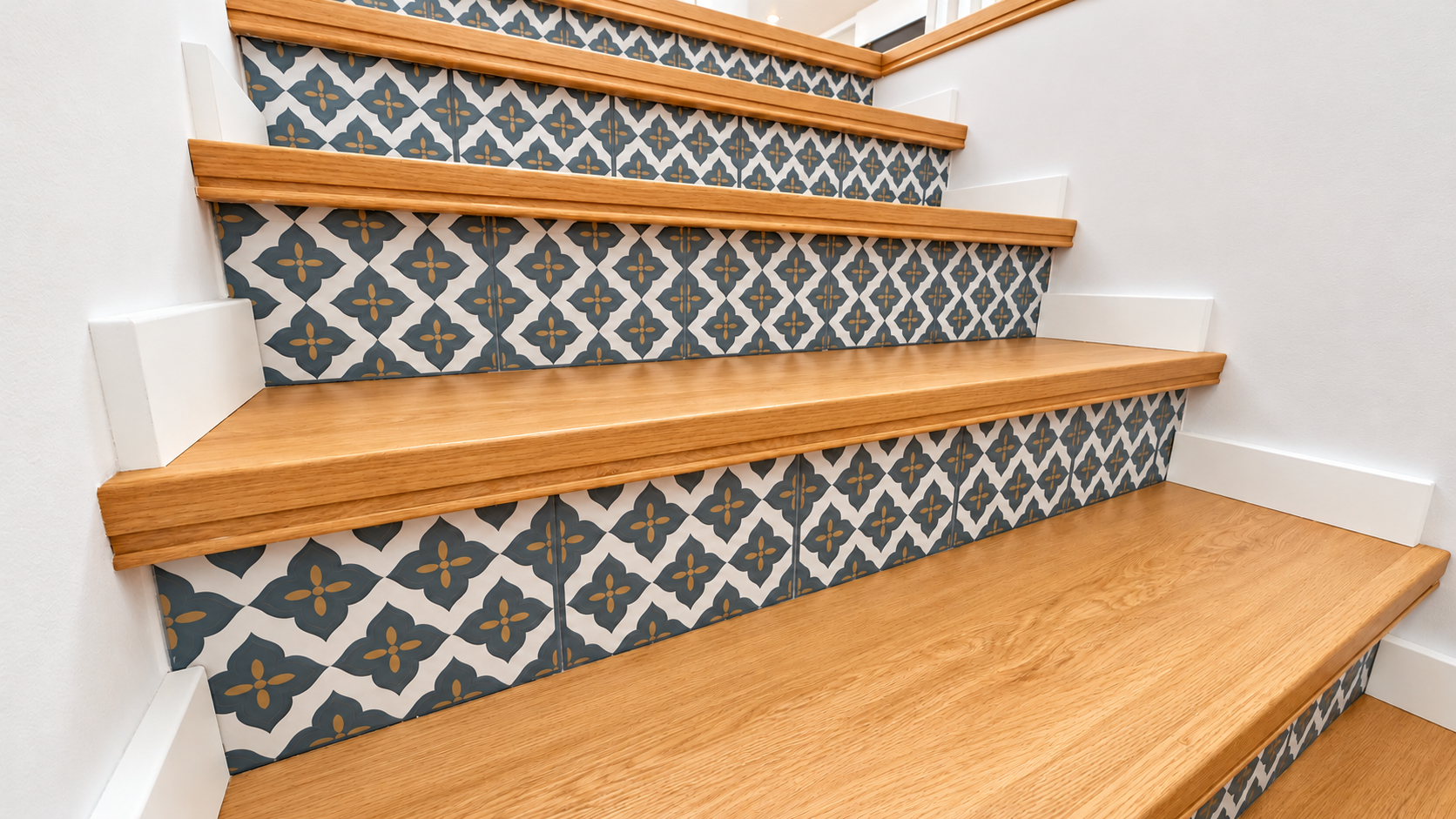 Staircase with wood-toned steps and floral tiles in Queijas