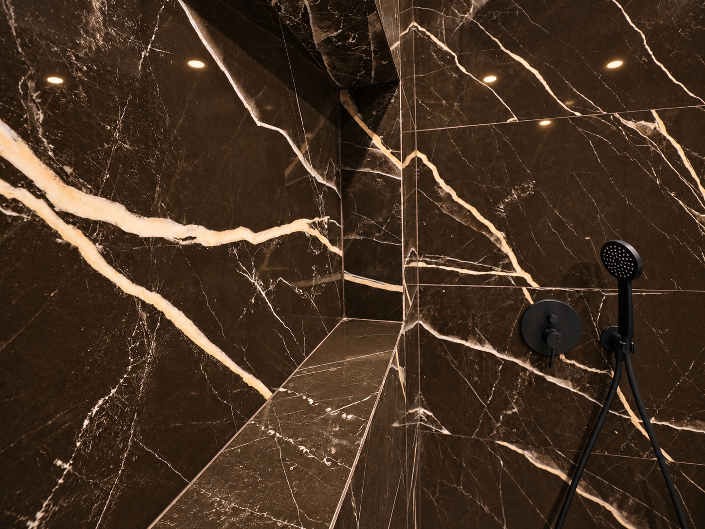 Black shower control and hand shower against dark finishes with light veining