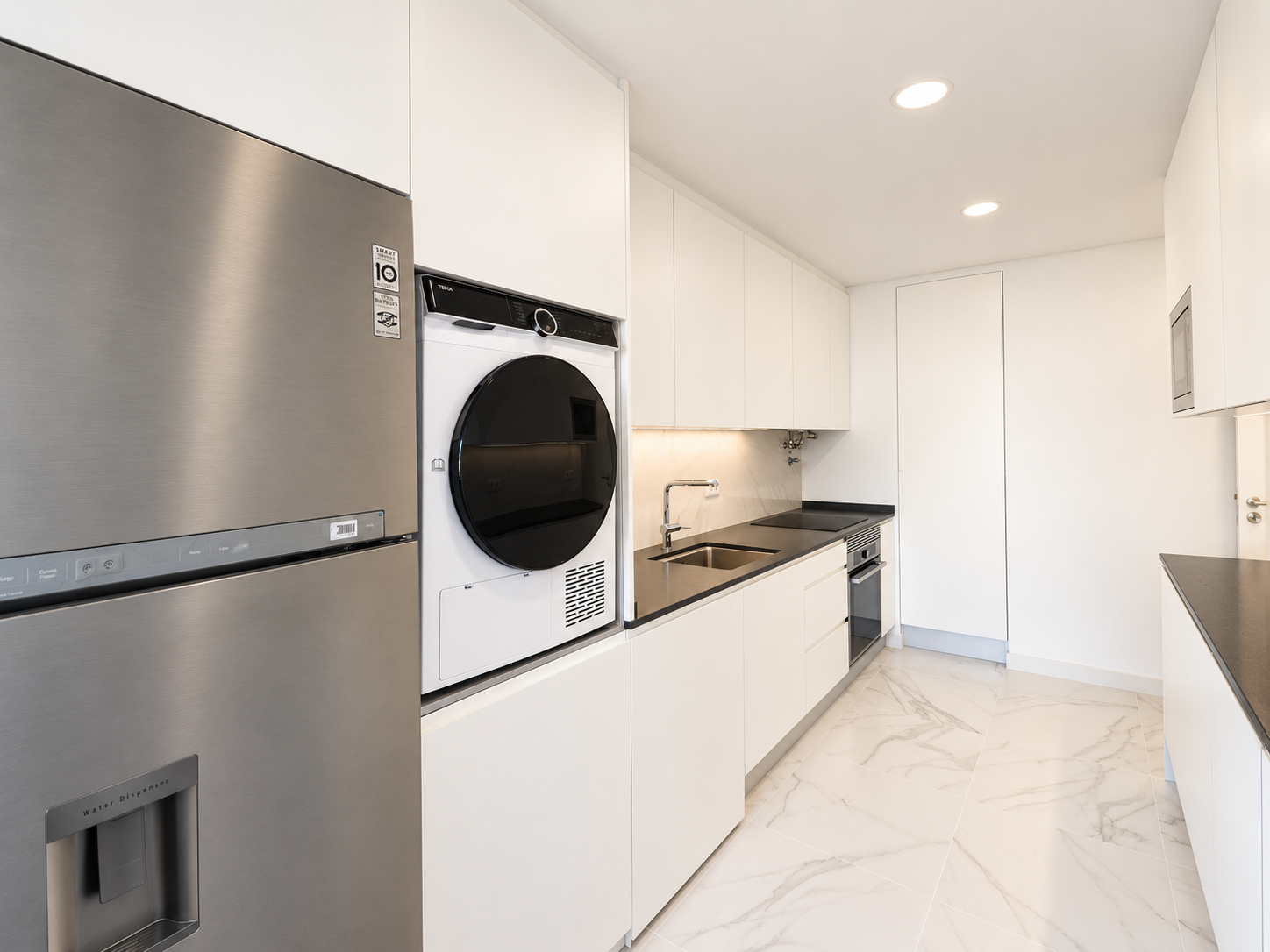 Fridge and appliances integrated into a run of white kitchen cabinets